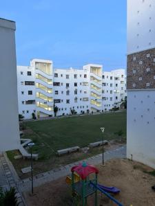 a playground in front of a large apartment building at Stylish 2BR Pool, Gym Garden in Mombasa +5 photos