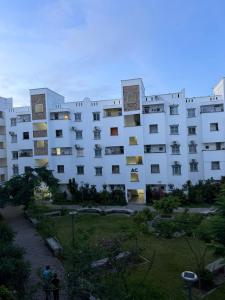a large white apartment building with a yard at Stylish 2BR Pool, Gym Garden in Mombasa