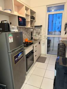 a kitchen with a refrigerator and a stove at Stylish 2BR Pool, Gym Garden in Mombasa