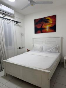 a white bed in a white room with at Stylish 2BR Pool, Gym Garden in Mombasa