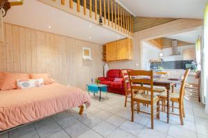 a bedroom with a bed and a table and a kitchen at La cabriole des lacs in Briel-sur-Barse