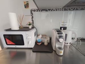 a kitchen counter with a microwave and a coffee maker at Rolando 20B in Genoa