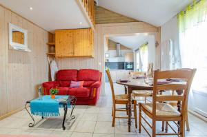 a living room with a red couch and a table at La cabriole des lacs in Briel-sur-Barse