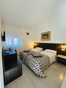 a hotel room with two beds and a desk at B&B Casaletto in San Nicola Arcella