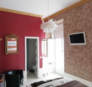 a living room with red walls and a tv on the wall at Legendary Bay - Suíte Temática in Seixal