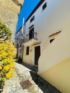 an alley with a white building with a balcony at B&B Casaletto in San Nicola Arcella