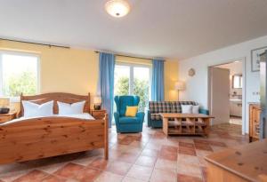 a bedroom with a bed and a couch and a chair at Dia Mare EG West in Ueckeritz