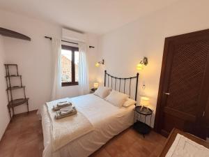 a bedroom with a bed with white sheets and a window at Es Quarteró in Sóller +17 photos
