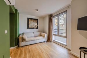 a living room with a couch and a large window at Love in Colours by PikHost in Durrës