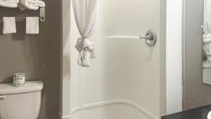 a bathroom with a toilet and a shower door with towels at Motel 6 - Pecos, TX in Pecos