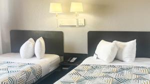 two beds with white pillows in a hotel room at Motel 6 - Pecos, TX in Pecos