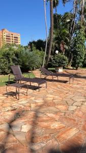 a group of benches sitting on a stone patio at Cardoso Palace Hotel Rio Verde in Rio Verde
