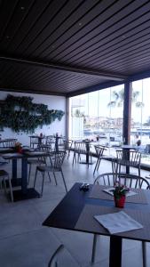 a restaurant with tables and chairs with a view of the water at Petit Hotel in Milazzo