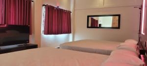 a hotel room with two beds and a television at Sas Tower Hotel in Trincomalee
