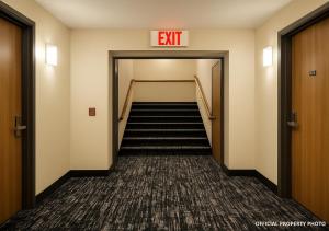 an exit sign in a hallway with stairs at Hotel Butler Inn in Butler