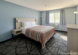 a hotel room with a bed and a window at Hotel Butler Inn in Butler