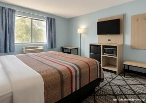 a hotel room with a bed and a flat screen tv at Hotel Butler Inn in Butler +12 photos