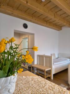 a room with a table with yellow flowers in a vase at Casa Via Viscri in Buneşti +76 photos