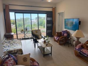 a living room with couches and a large window at J'Vais Residence in Flic-en-Flac