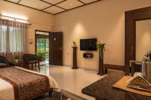 ein Hotelzimmer mit Bett und Flachbildfernseher in der Unterkunft Bononi in Jorhat