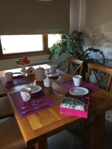 a wooden table with purple napkins and plates on it at Complejo Puelo Altos de Golondrinas in Golondrinas +16 photos