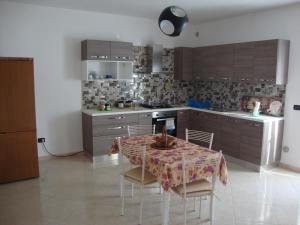a kitchen with a table and chairs in a room at La Villa Bianca in Lama