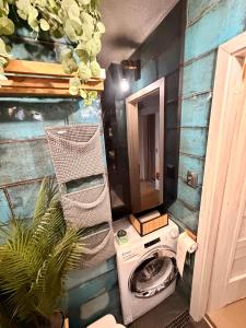 a bathroom with a washing machine and a mirror at Glamour Apartment in Konin