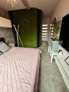 a bedroom with a bed and a green wall at Glamour Apartment in Konin