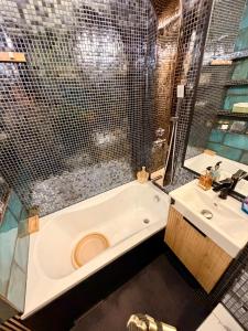 a bathroom with a tub and a sink at Glamour Apartment in Konin