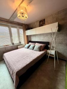 a bedroom with a large bed and a chandelier at Glamour Apartment in Konin