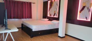 a small bedroom with a bed and a television at Sas Tower Hotel in Trincomalee