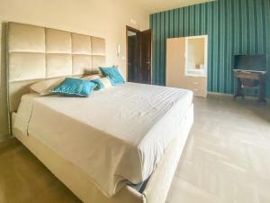 a large white bed with blue pillows in a bedroom at Blue Room - Camera Matrimoniale con Garage Privato in Bitonto