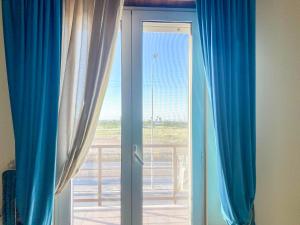 a sliding glass door with a view of the ocean at Blue Room - Camera Matrimoniale con Garage Privato in Bitonto