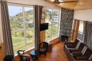 a living room with a couch and a fireplace at Hotel Amadeus in Kanatal