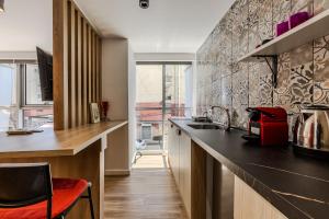 a kitchen with a counter and a red chair at Love in Colours by PikHost in Durrës