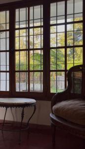 a room with windows and a chair and a table at Casa de Barro in Junín