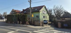 a green house on the side of a street at Apartament w Komornikach in Komorniki