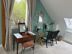 a desk and chairs in a room with a window at Villa Omaha in Saint-Laurent-sur-Mer