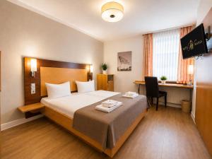 a hotel room with a bed and a desk at Hotel Wania in Hamburg