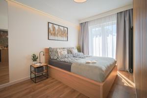 a bedroom with a bed and a large window at Mała Poleska - przytulny apartament z ogródkiem in Częstochowa