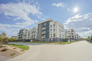 an apartment building on a street with the sun in the sky at Mała Poleska - przytulny apartament z ogródkiem in Częstochowa