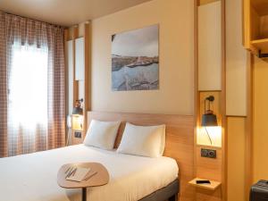 a hotel room with a bed and a table at IBIS STYLES Rouen Parc Expos Zenith in Saint-Étienne-du-Rouvray +46 photos