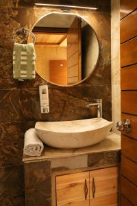 a bathroom with a large sink and a mirror at Hotel Amadeus in Kanatal +49 photos