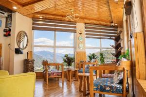 a dining room with a table and chairs and a large window at Hotel Amadeus in Kanatal