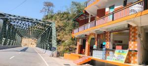 a bridge over a road next to a building at Hotel suryoday kharadi in Barkot
