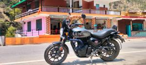 a black motorcycle parked on the side of a street at Hotel suryoday kharadi in Barkot