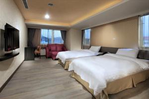 a hotel room with two beds and a television at West Hotel in Puli