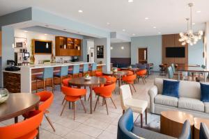 a restaurant with tables and chairs and a bar at EVEN Hotel Alpharetta - Avalon Area by IHG in Alpharetta