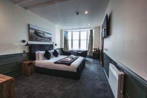 a hotel room with a bed and a desk at The Royal Bar & Shaker in Morecambe