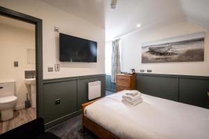 a hotel room with a bed and a tv on the wall at The Royal Bar & Shaker in Morecambe +12 photos